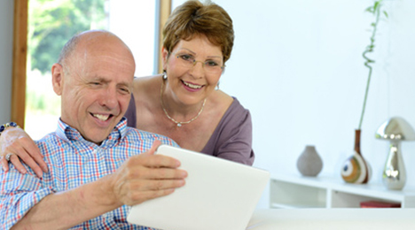 Couple souriant devant une tablette