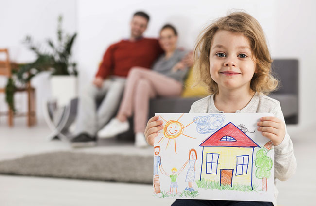 petite fille montrant un dessin de maison