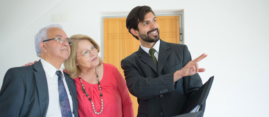 Agent immobilier présentant un logement neuf à un couple d'acheteurs