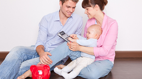 couple avec un bébé autour d’une calculatrice