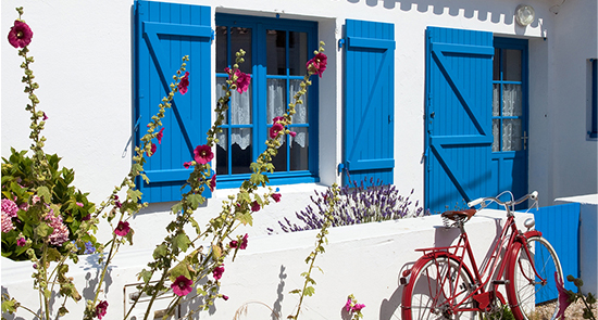 Façade d'une maison de bord de mer aux volets bleus