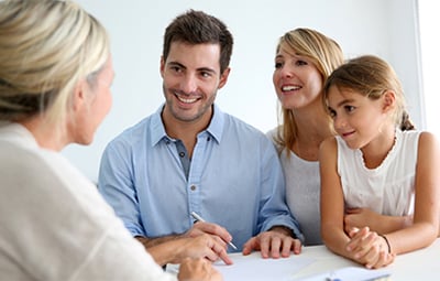 Famille discutant avec une conseillère en immobilier