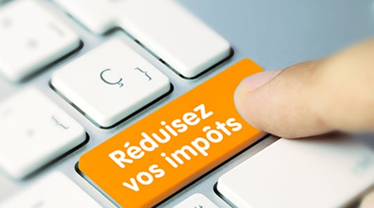 La touche d'un clavier d'ordinateur portant l'inscription 'Réduisez vos impôts'