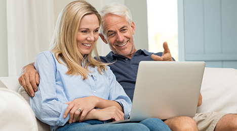 Couple souriant devant un ordinateur