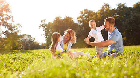 Parents avec 2 enfants devant leur maison